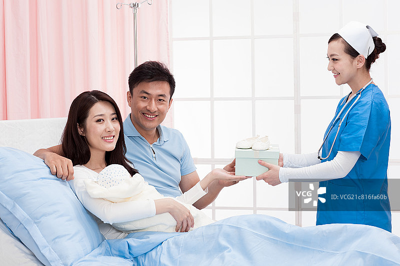 护士给青年夫妇送礼物图片素材