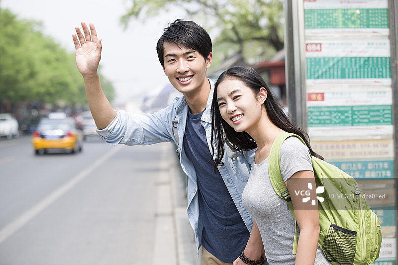 年轻情侣在公交站等车图片素材