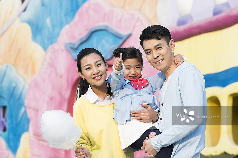 快乐的一家三口去游乐园玩图片素材