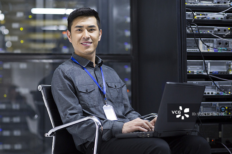 商务人士在机房使用笔记本电脑图片素材