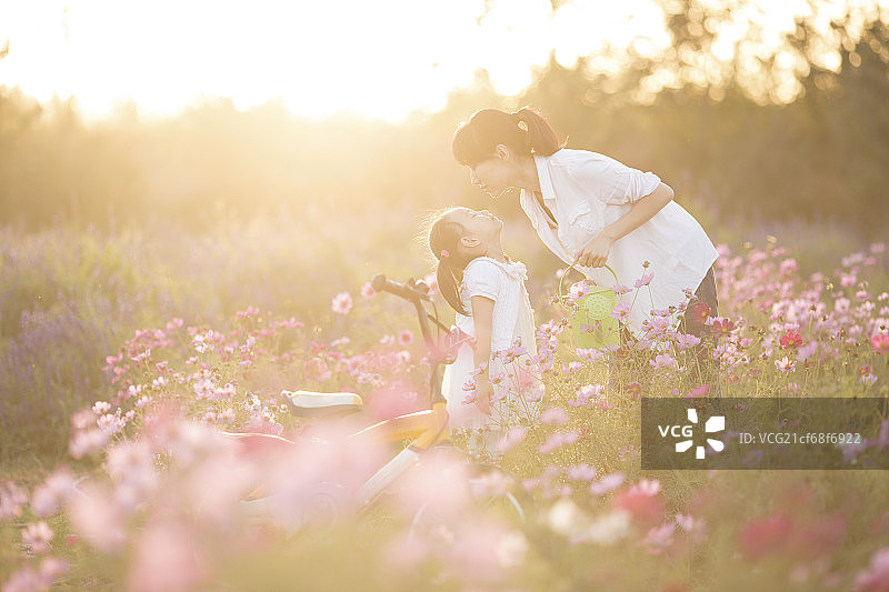 年轻的妈妈带女人在花园里浇花图片素材