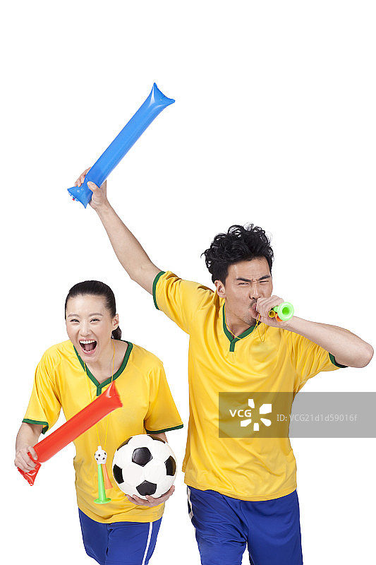一对穿足球队服挥臂加油的青年情侣图片素材