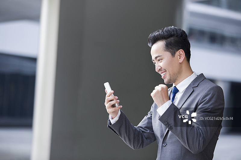 兴奋的商务男士看着手机图片素材