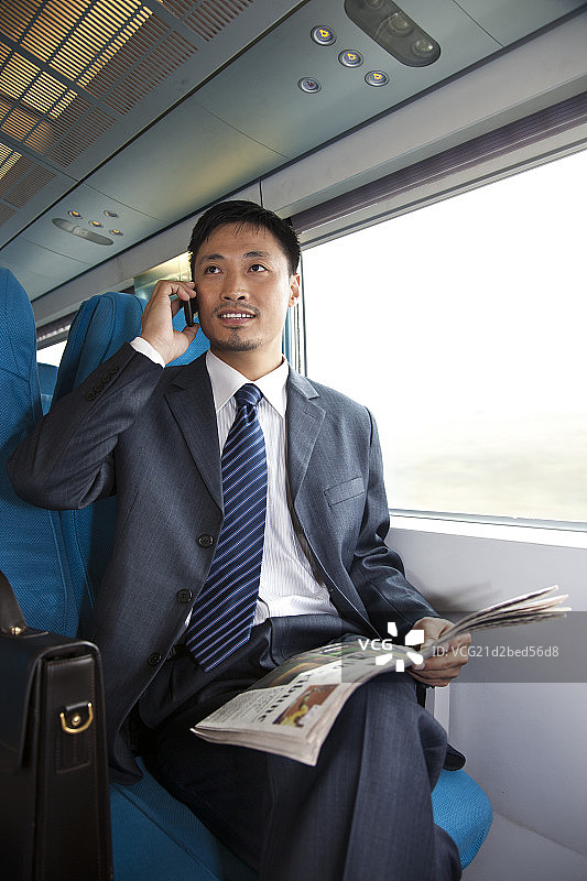 年轻商务男士在车厢里看报纸图片素材