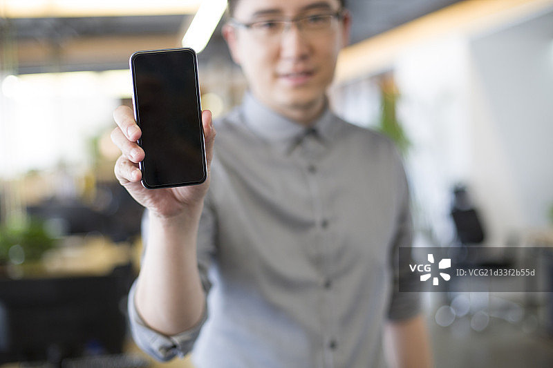 IT工作者在办公室展示手机图片素材