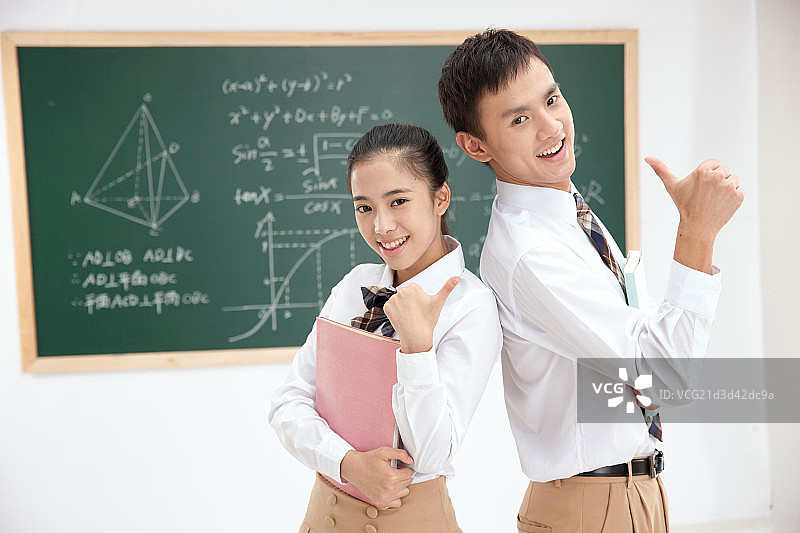 两个中学生在教室里竖起大拇指图片素材