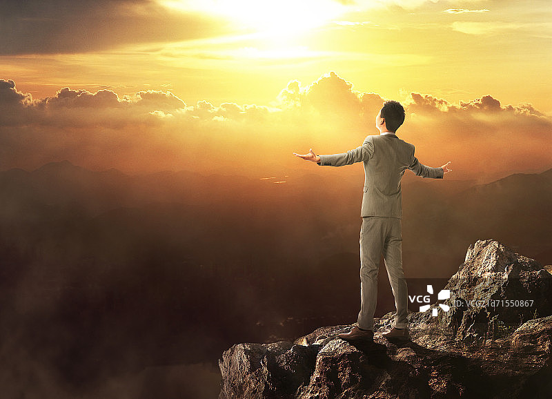 青年商务男人站在山顶上图片素材
