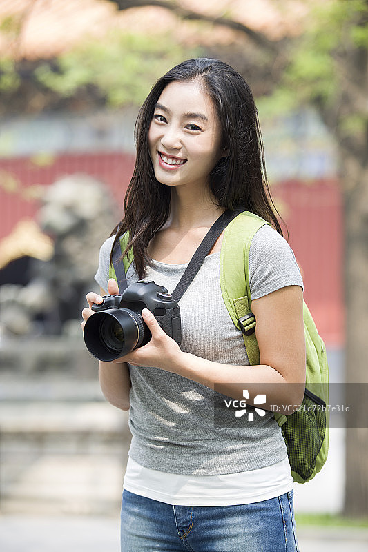 年轻女子拿着相机在雍和宫旅游图片素材