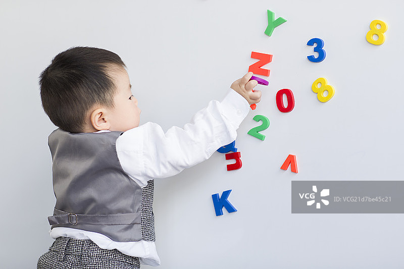 可爱的宝宝玩数字和字母玩具图片素材