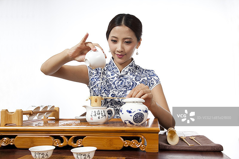 棚拍身穿中国传统服装的年轻女人秀茶艺图片素材