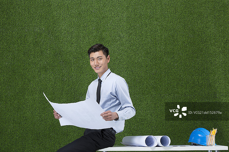 草地商务男设计师看图纸图片素材