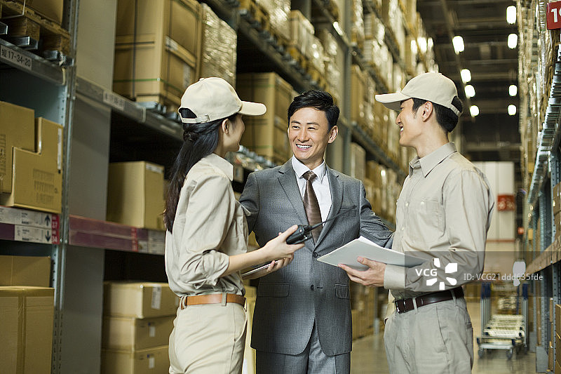 物流工作人员在仓库讨论图片素材
