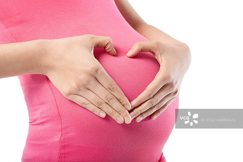 手放肚子上摆出心形造型的孕妇图片素材