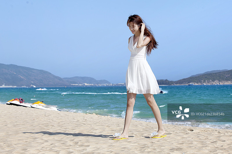 身穿白裙子度假中的年轻女士图片素材