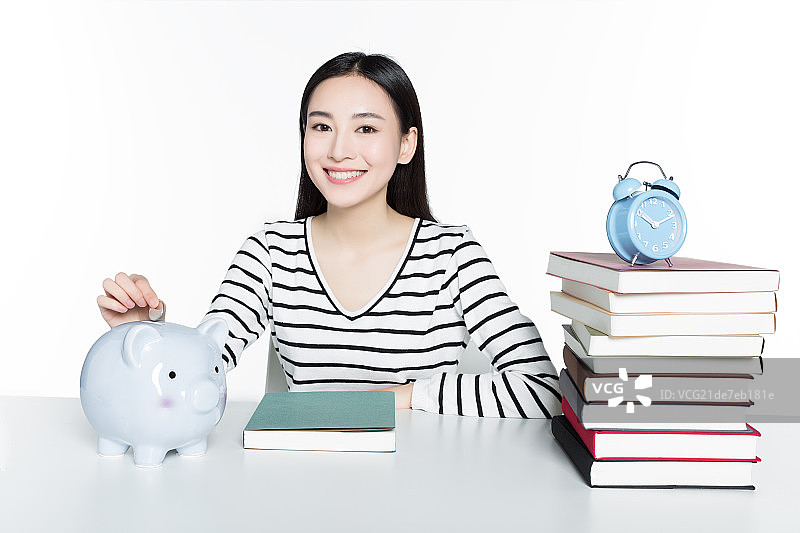 少女把钱放入存钱罐图片素材