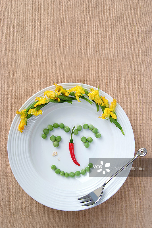 盘子上蔬菜组成的面具图片素材