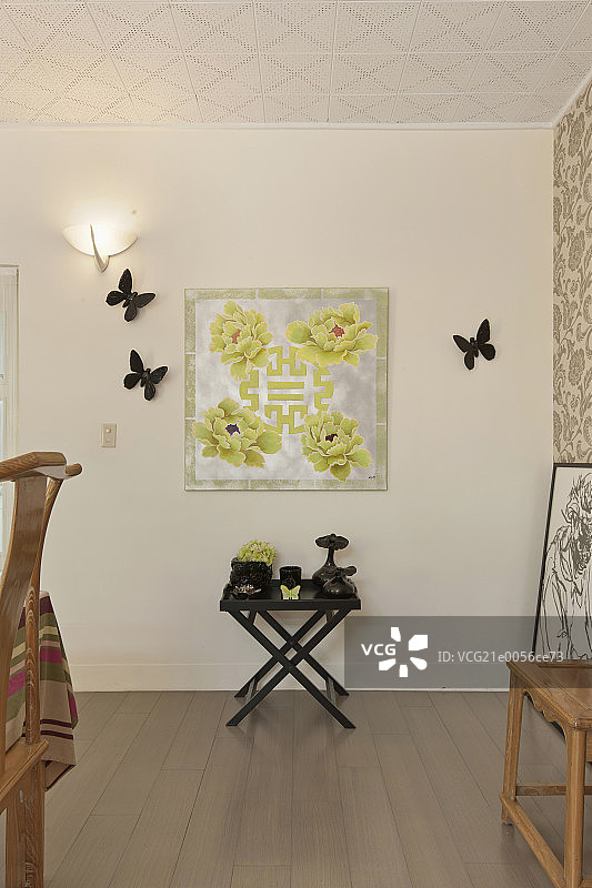 Artifacts on a side table against decorated wall at home图片素材