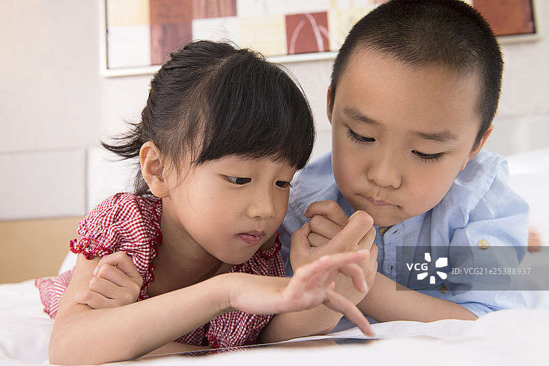 Boy and girl using tablet in bed图片素材