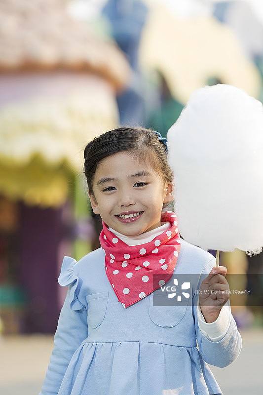 小女孩在游乐园吃棉花糖图片素材