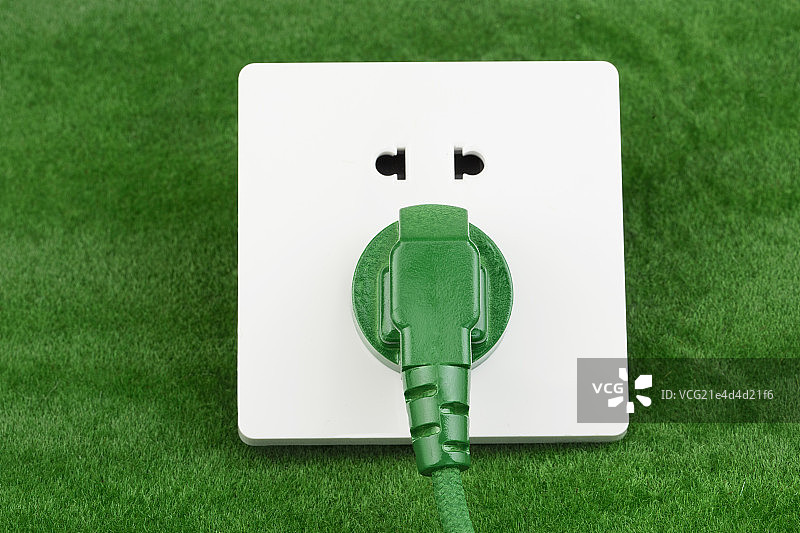 放在草坪上的电源插头图片素材