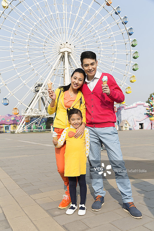 快乐的一家三口去游乐园玩图片素材