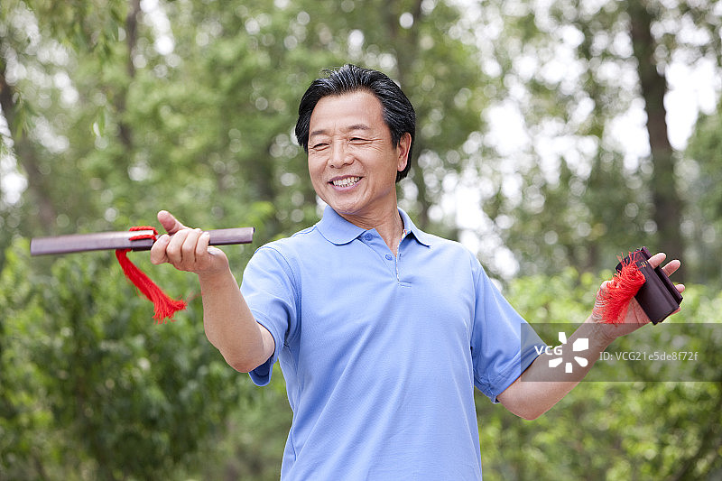老年男子在公园玩快板图片素材