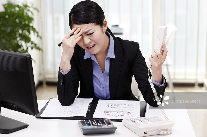 商务女士看资料夹时打电话图片素材