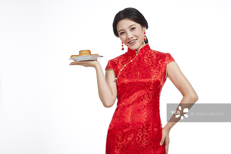 棚拍身穿中国传统服装的年轻女人端月饼图片素材
