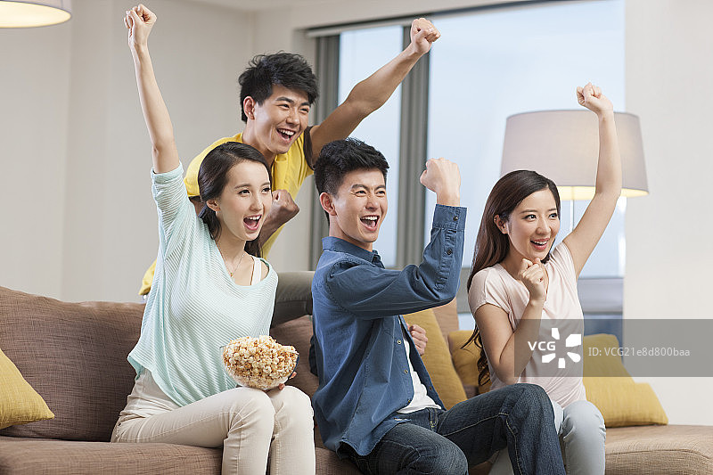 年轻人在客厅一起看体育比赛图片素材