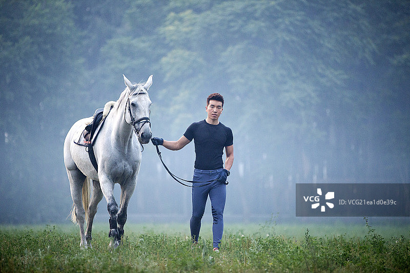 青年男人牵着马图片素材
