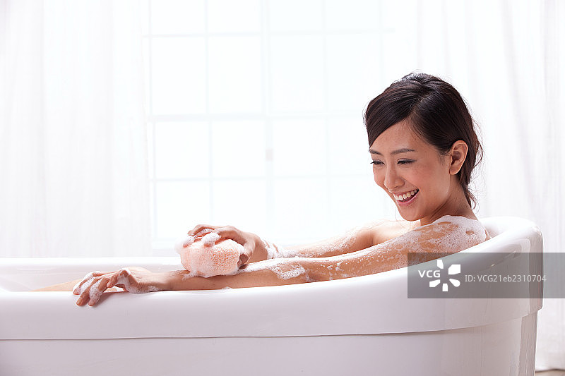 一个年轻女人坐在浴缸中图片素材