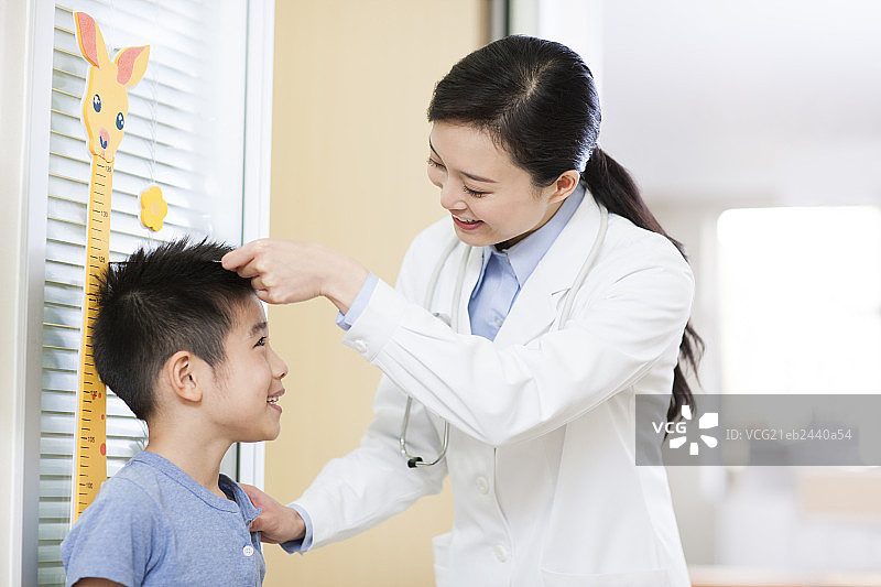 医生给小男孩量身高图片素材