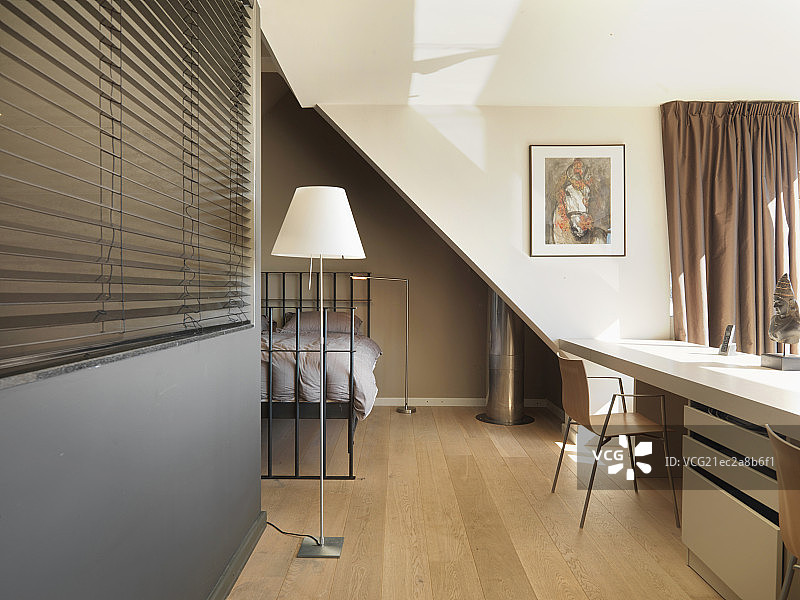 Chair at long table and blinds along hallway with bed in the background at home图片素材