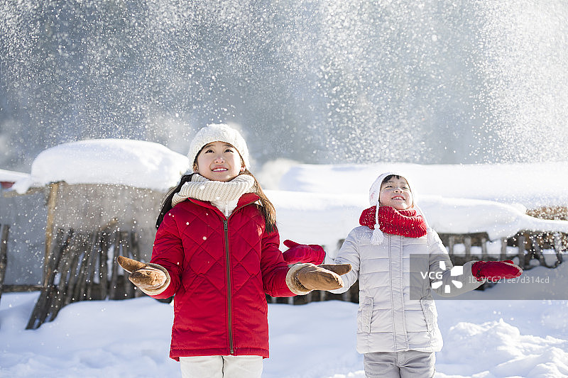 两个女孩伸手接飘落的雪花图片素材