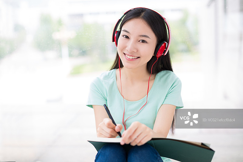 教学楼里听音乐的女大学生图片素材