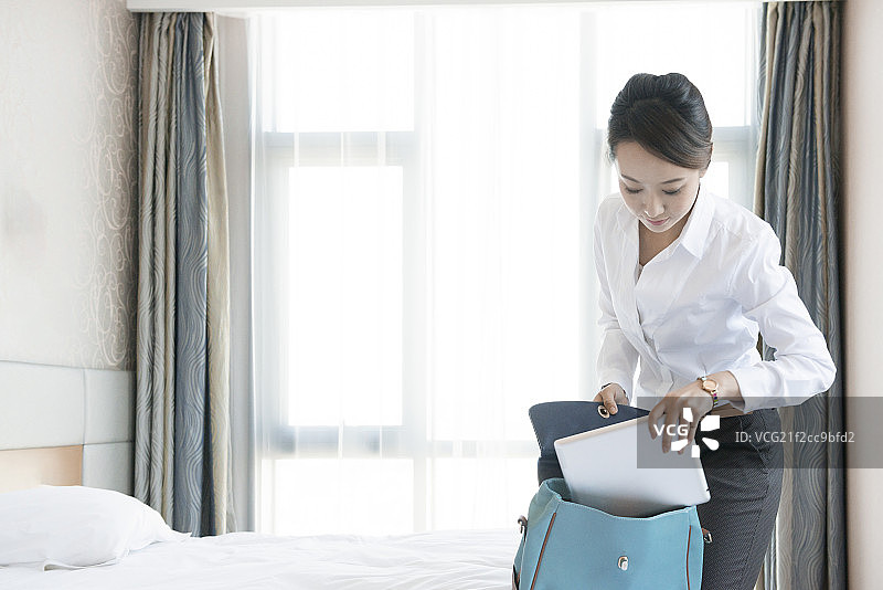 Young woman packing for work图片素材