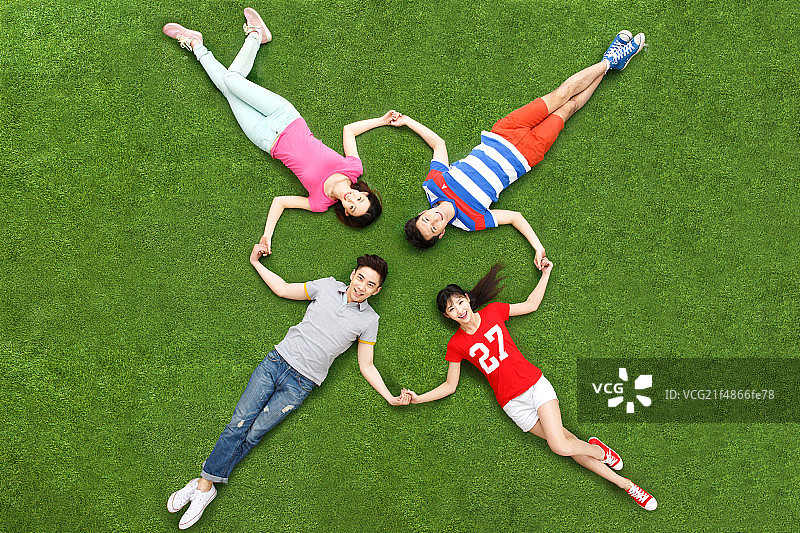 休闲的青年男女躺在草地上图片素材