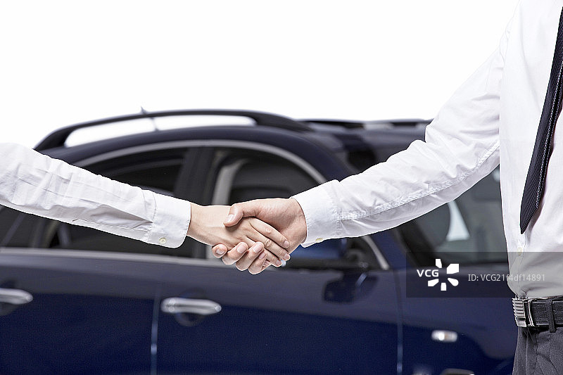 站在汽车前握手的商务男女图片素材