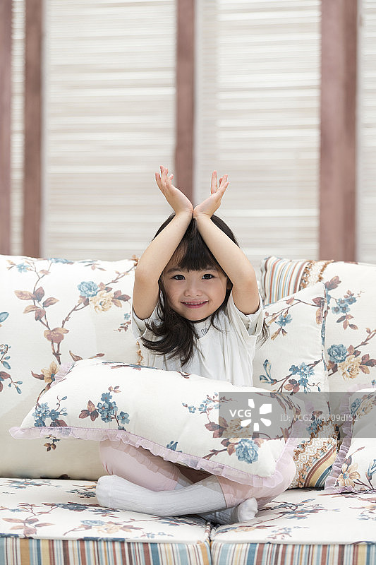 快乐的小女孩坐在沙发上图片素材