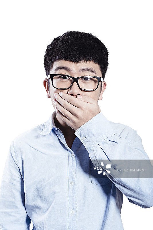 Young man covering mouth图片素材