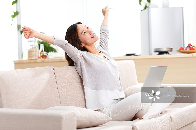 年轻女人坐在沙发上图片素材