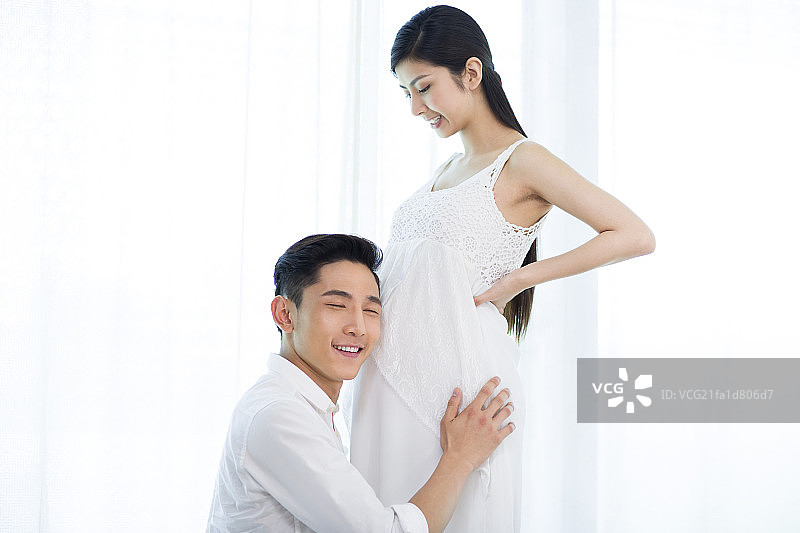 父亲聆听胎儿的动静图片素材