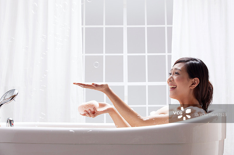 一个年轻女人坐在浴缸中图片素材