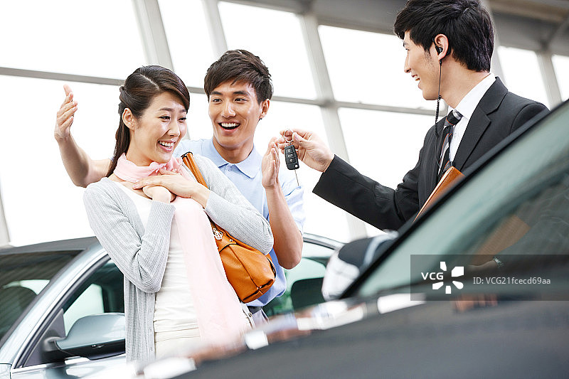青年夫妇在4S店购买汽车图片素材
