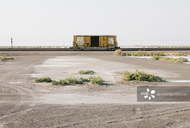 沙漠中火车轨道上的空车厢或货车车厢图片素材