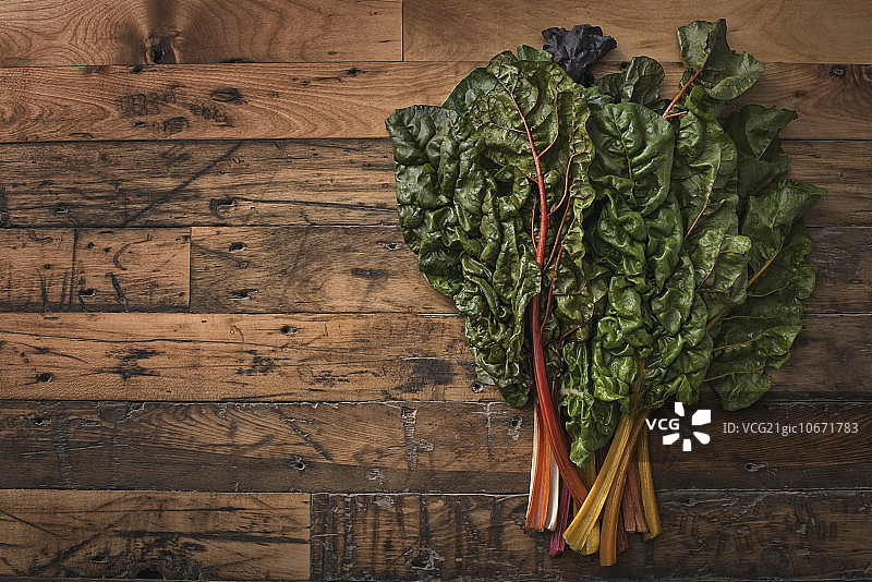 木板上的红橙色莙荙菜叶图片素材