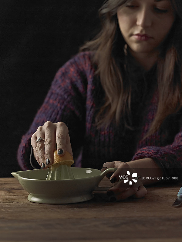 女人在木桌上榨橙汁图片素材