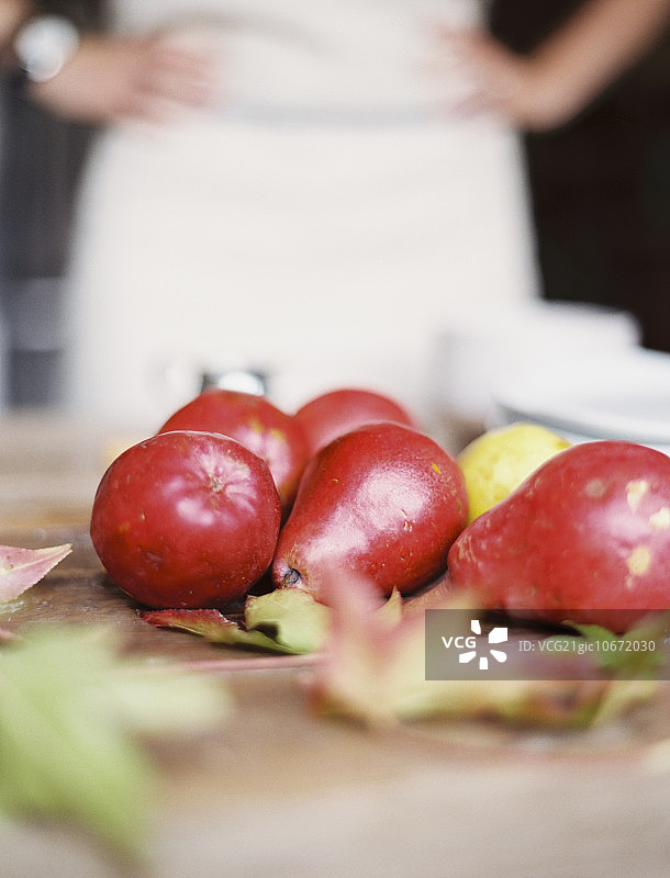 厨房台面：少量新鲜有机梨和一叠白盘子图片素材