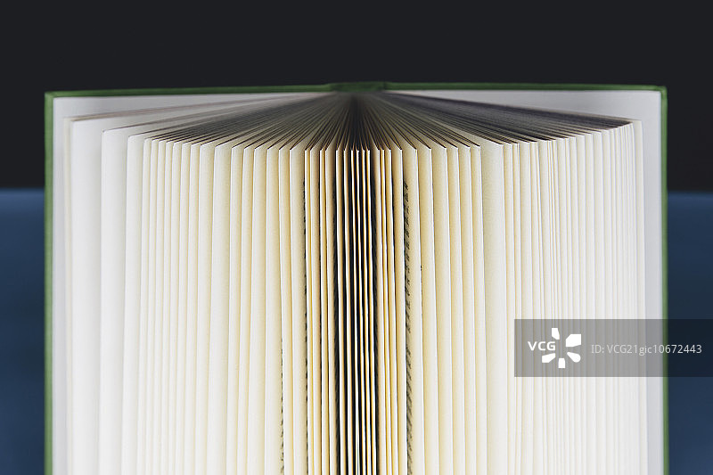 一本打开的精装书，书页边缘泛黄，中心呈棕黑色图片素材