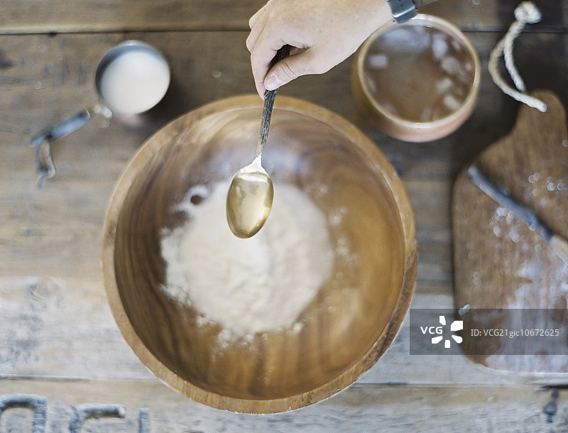 家庭厨房：厨师准备食物，一个装满油和面粉的大碗，制作糕点。图片素材